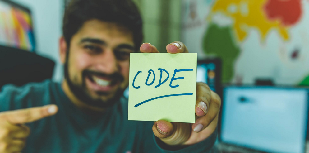 man holding a paper with code written on it